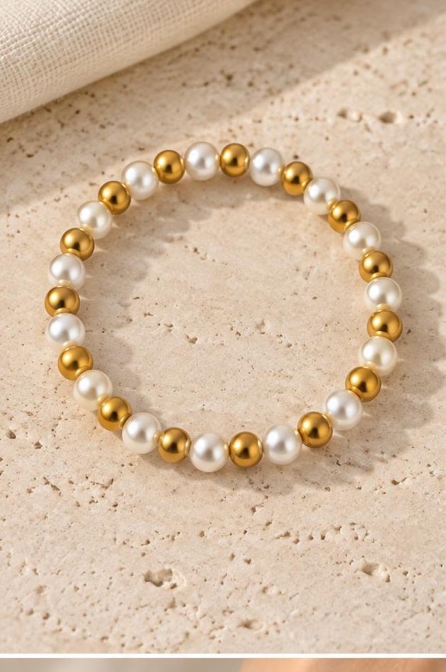 White & Gold-tone Bead Bracelet on travertine